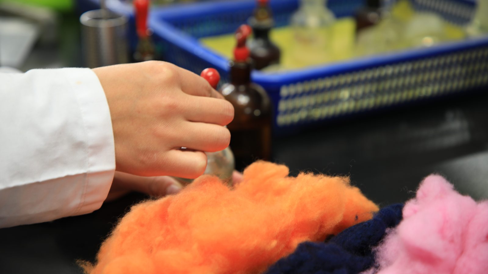 Technician matching a dye recipe against dyed cashmere fibre in our colour lab