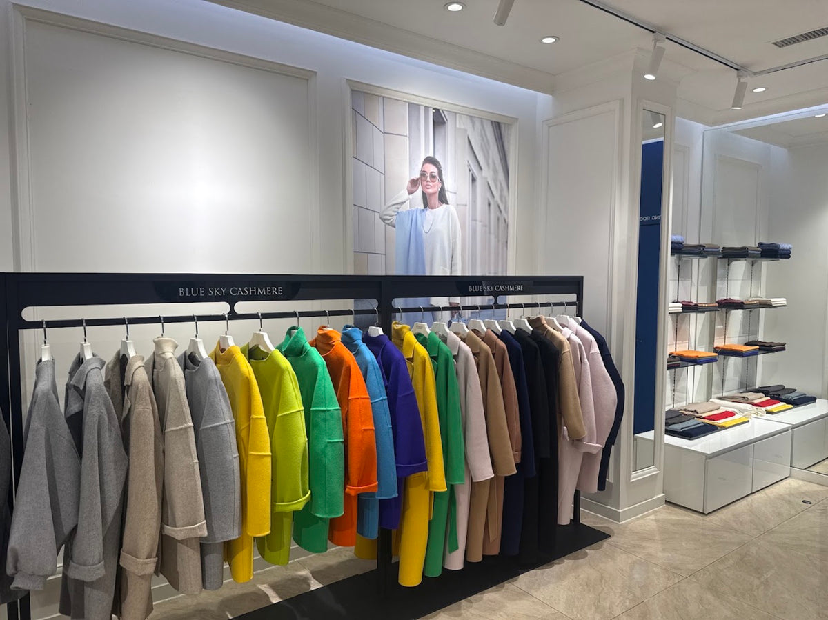 Kaschmirmäntel in der vollen Farbpalette auf den Kleiderstangen von Blue Sky Cashmere